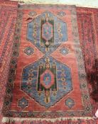 Afghan rug in red with blue, brown and red designs in centre (large tear close to border), 160cm x