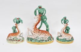Set of three Staffordshire pottery 19th century models of giraffes in two sizes, each modelled