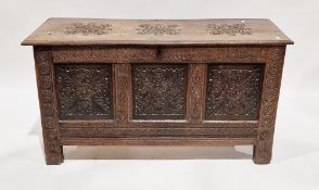 17th/18th century oak coffer, the hinged lid carved with three motifs opening to an empty space, the