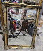 Modern rectangular bevelled edge mirror, the ornate gilt and ebonised frame moulded with scrolling