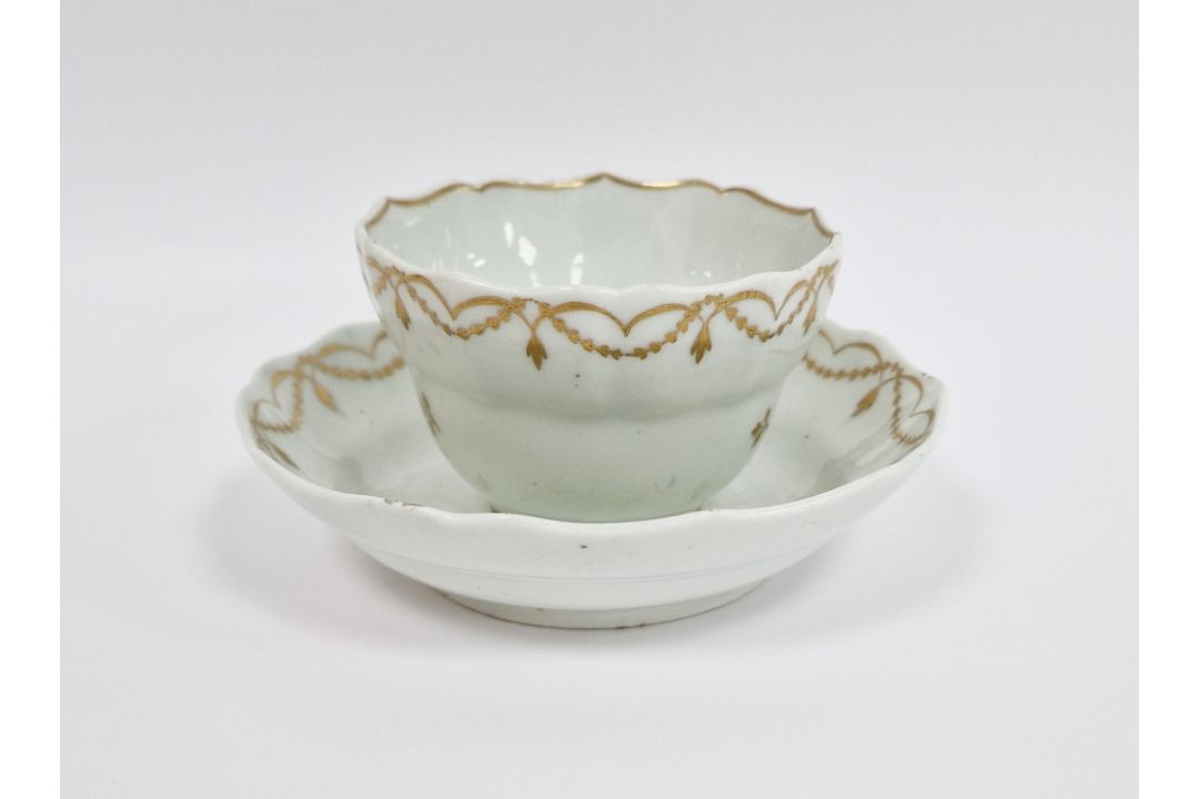 Lowestoft white and gilt ogee-shaped teabowl and saucer, circa 1790, gilt with scattered sprigs