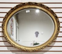 Gilt framed oval mirror with scrolling moulded edge and bevelled plate, 58cm long