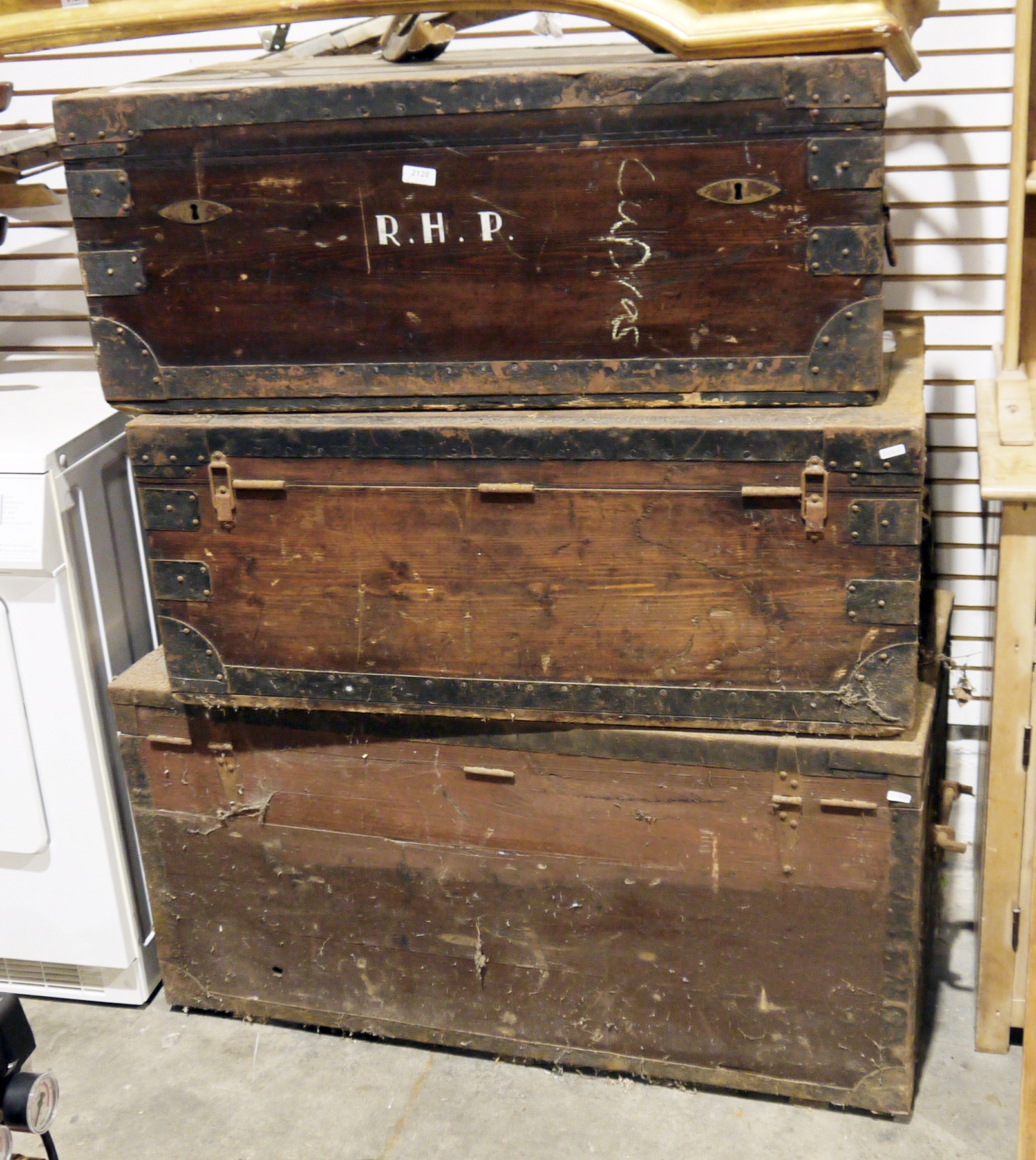 Three late 19th/early 20th century stained pine and iron bound travelling trunks, largest 106cm long