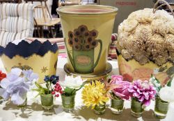 Various decoupage flower planters, various posies of faux-flowers made by Bloom and a decorative