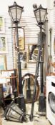 Three black painted metal electric Victorian style street lanterns on posts, each top with six