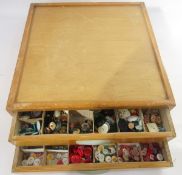 Mid-century haberdasher's two-drawer table-top button cabinet, each drawer full of assorted coloured