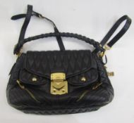 A black quilted Miu Miu bag with gilt hardware, flap front, two pockets to the front and one to