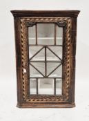 Early 19th century oak hanging corner cabinet, the glazed panel door with carved decoration