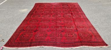 Large Persian carpet on red ground with 35 gul medallions in brown, red and black with floral