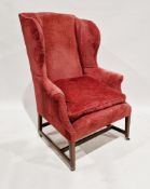 Wing back armchair in the George III manner, upholstered in a pinkish red fabric with loose
