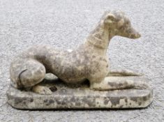 Composite stone garden statue of a recumbent greyhound, 40cm high x 68cm long