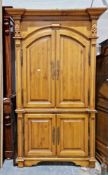 Continental pine cupboard, the moulded inverted breakfront cornice over two arched panel doors and