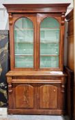 Victorian mahogany library bookcase cupboard, the moulded cornice over two arched glazed doors