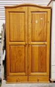 Modern pine domed top wardrobe, one cupboard door opening to a hanging space and the other to