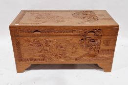 20th century South East Asian camphorwood blanket chest, the lid and sides carved with scenes of a