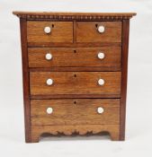 Late Victorian oak small table-top chest of drawers, the moulded top with egg and dart above two