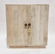 20th century limed oak side cabinet, the two reeded panel doors with brass handles, opening to a