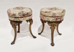 Pair of circular stools with double-cushion upholstered seats and raised on three gilt metal