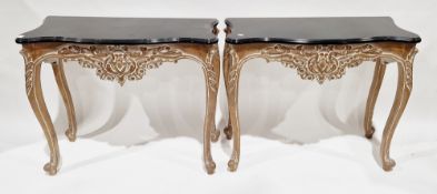 Pair of 20th century console tables in the French Louis XV manner, each with a shaped top with black