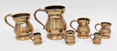 Set of seven 19th century graduating bronze tankard measures of baluster form with scroll handles,