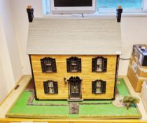 Kit built dolls house with slate effect roof and wooden panel effect walls, the front panel
