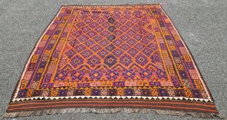 Uzbek kilim in blood orange with indigo hooked medallions in a lozenge trelliswork, flanked by