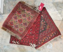 Set of three small Persian rugs with red grounds, 44cm x 52cm, 50cm x 63cm and 50cm x 62cm (3)