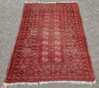 Persian rug on red ground elephant foot guls, two rows of 10 cream, orange and brown with
