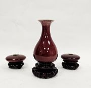 Chinese Qing Dynasty flambe sang-de-boeuf ground bottle-shaped vase and two brush washers, on carved