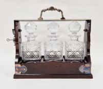 Early to mid 20th century mahogany and silver plated tantalus holding three matching hobnail cut