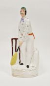 Staffordshire pottery figure of a cricketer, circa 1865, modelled standing wearing a green cap and