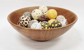 Large turned wooden bowl containing a collection of handpainted balls with decorative designs and