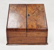 Late Victorian walnut stationery cabinet, the sloping twin doors opening to a fitted stationery rack