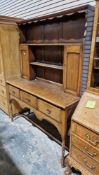 Early 20th century oak dresser in the 18th century manner, the upper section with shelf and two