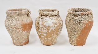 Set of three terracotta jars with integral holes for rope handles and bearing encrustation, 30cm