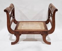Modern hardwood seat in the French Empire manner with double scrolling arms and cane seat, raised on