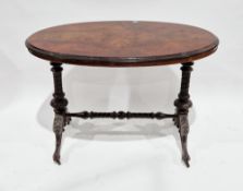 Victorian walnut side table, the oval quarter-veneered top over two carved supports with carved