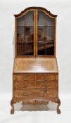 Early 20th century walnut and burr walnut bureau bookcase, the moulded domed pediment over two