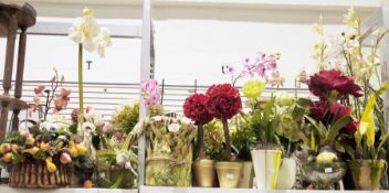 A quantity of faux floral arrangements contained within various glass or ceramic planters, to
