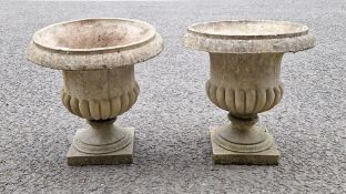 Pair of half gadrooned jardiniere urns on stands and a further jardiniere urn on stand bearing grape