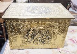 An embossed brass covered coal box bearing a street scene on the lid and front