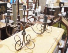 A pair of wrought iron five branch scrolled candelabra (2)