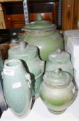Four green glazed Chinese pottery lidded jars in varying sizes, along with a crackle glazed style
