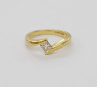 18ct gold and solitaire diamond ring of crossover design, set with a central princess cut diamond,