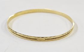 A gold-coloured metal bangle with engraved decoration, marked 333, 8g approx