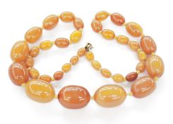 Graduated amber bead necklace, approx. 71cm long, the largest central bead approx. 3.25cm long