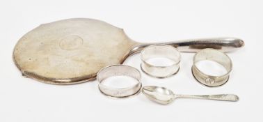Silver-backed hand mirror, three napkin rings and a silver spoon, the mirror engine-turned, rubbed