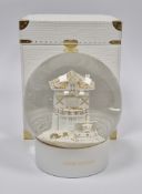 Louis Vuitton snowglobe in original box, the centre with a white and gilt model of the facade of the