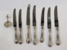 Seven sterling handled knives, floral and scroll decorated, and continental silver small caddy spoon