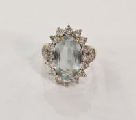 18ct gold, aquamarine and diamond cluster ring, the large oval aquamarine surrounded by small